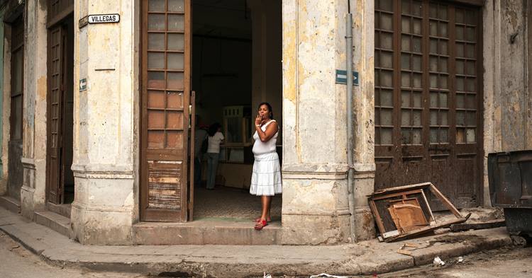 zena ispred zgrade na Kubi
