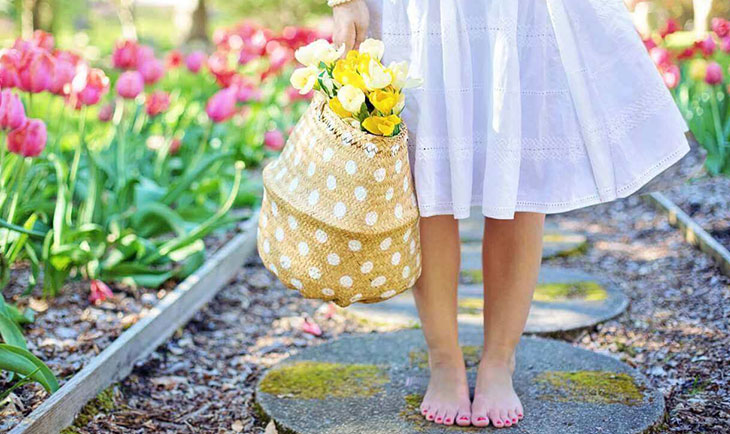 Bosa devojka drži korpu sa cvećem