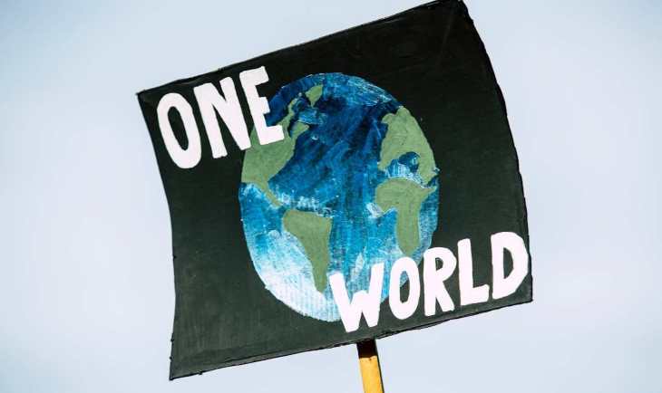 Transparent na kojem je naslikana zemlja i na kojima pišu reči “One World”