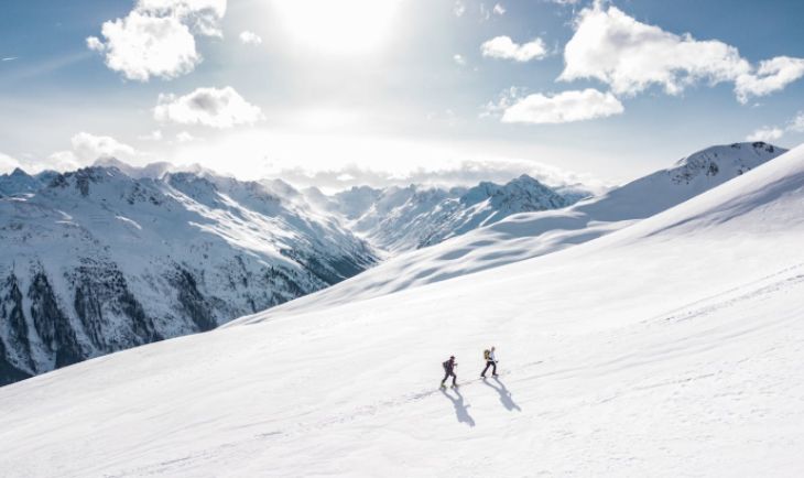 Dva čoveka na skijama na planini.