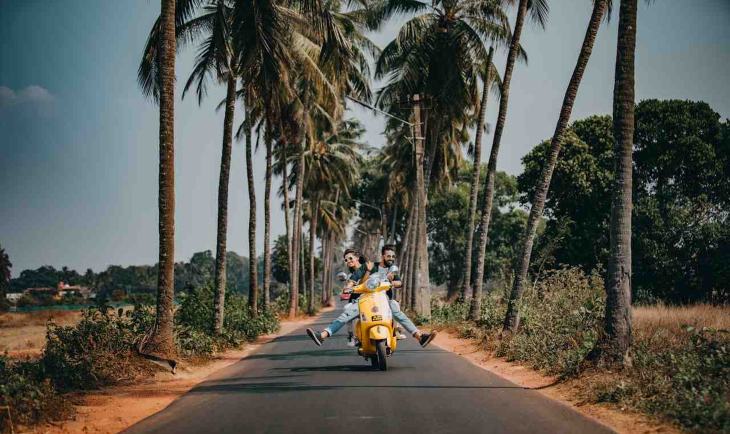 Devojka i mladić na skuteru.