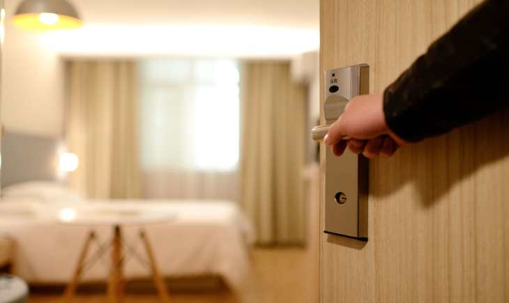 Čovek otvara vrata hotelske sobe