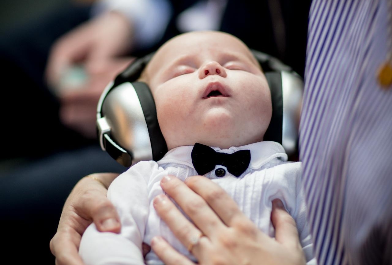 Beba spava sa slušalicama u krilu.
