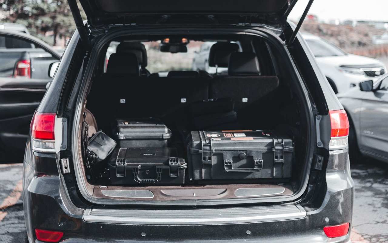 Otvoren gepek automobila u kome su poređane kutije za alat